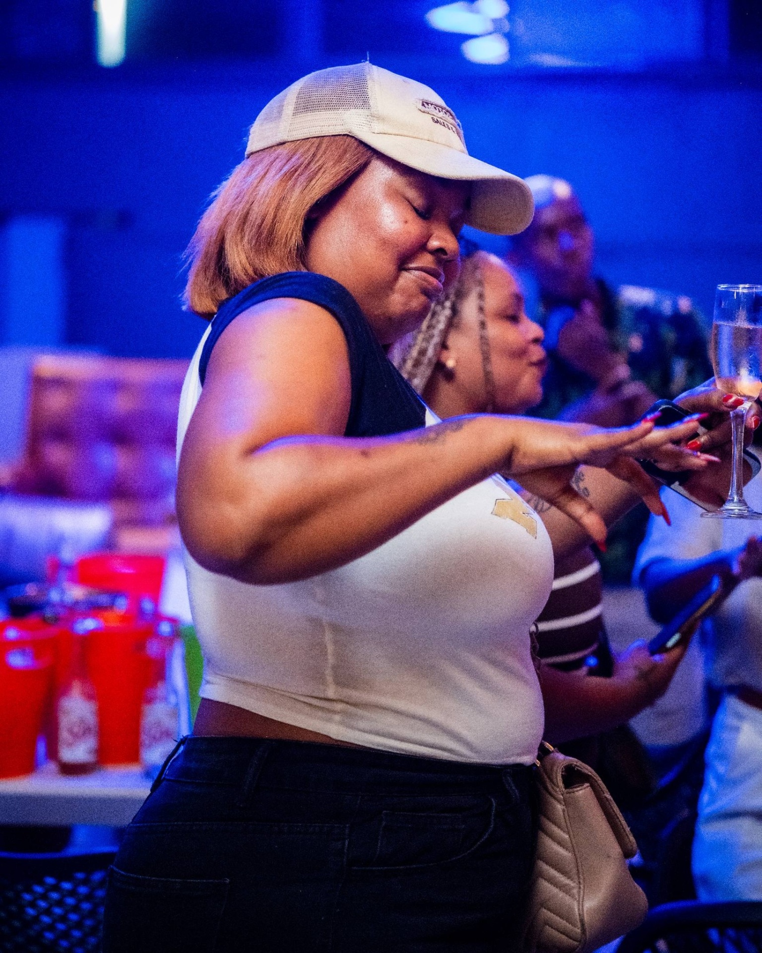 Guest dancing with a drink under blue lights