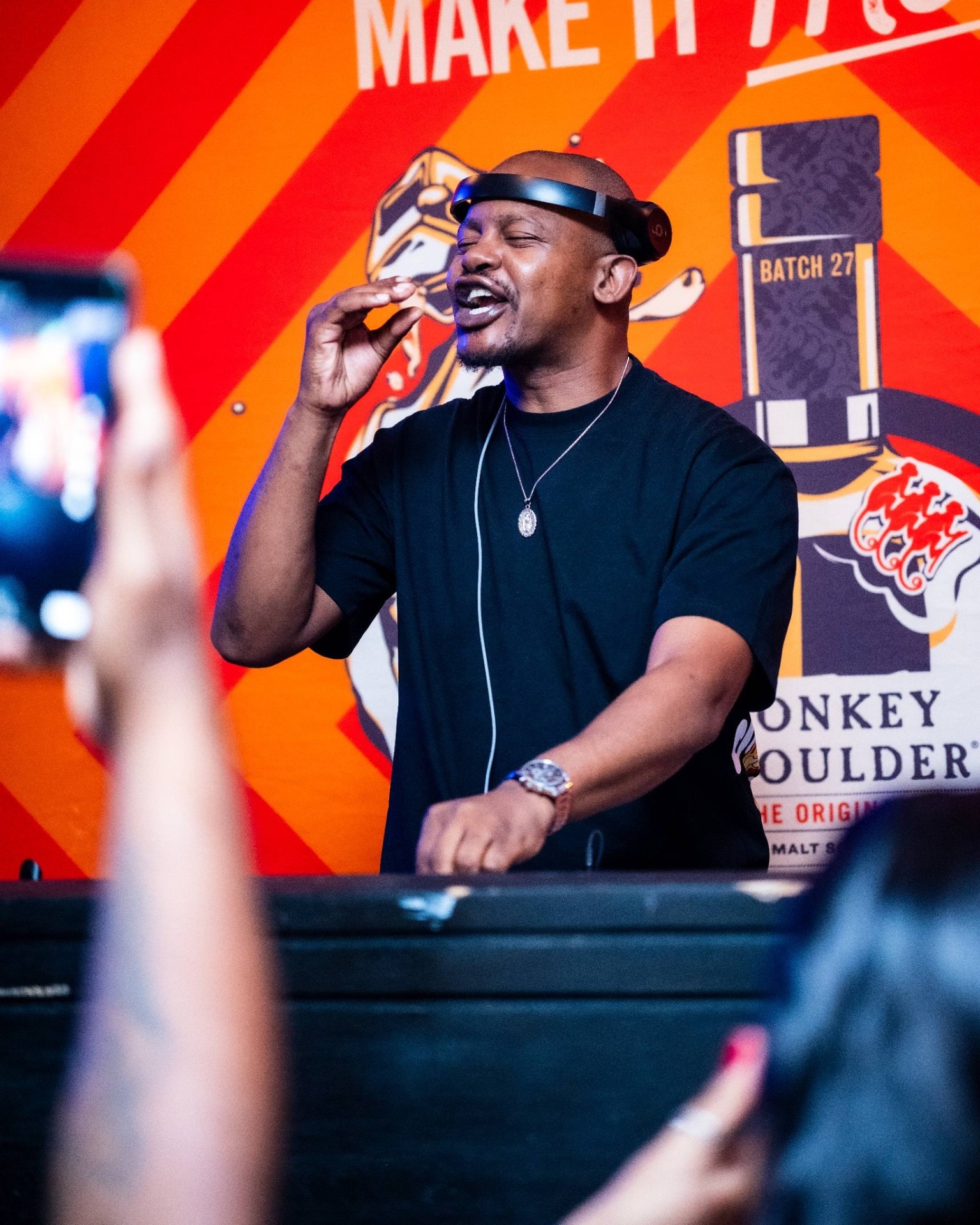 DJ vibing into the mic with crowd phones up